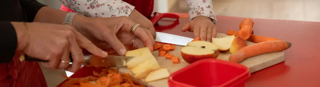 Mutter und Kind kochen gemeinsam und bereiten Lebensmittel zu.