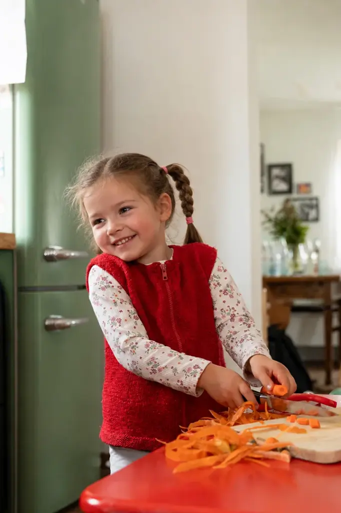 Kind lacht und kocht in Küche